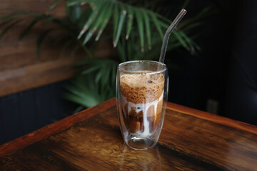 Traditional Vietnamese egg coffee with condensed milk and creamy foam on wooden table in a glass, copy space. Concept of enjoying unique Asian beverage and cultural coffee experience.
