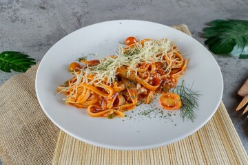 Delicious Spaghetti Pasta with Tomato Sauce and Fresh Basil on White Plate