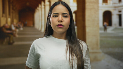 Fototapeta premium Woman standing in historic outdoor setting with arches in old town suggests exploration travel adventure and cultural immersion.