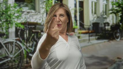 Fototapeta premium Caucasian woman counting fingers while celebrating and smiling beside bicycles on sunlit street; joy success celebration achievement.