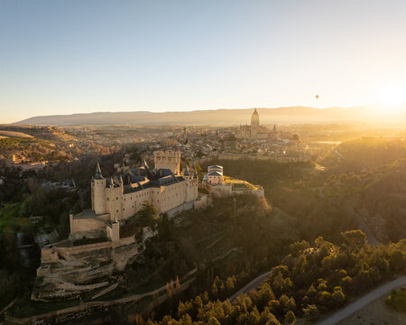 Aerial view of the Alc&Atilde;&iexcl;zar de Segovia standing grandly as golden sunlight bathes the ancient stones and surrounding landscape, Segovia, Castilla y Le&Atilde;&sup3;n, Spain.