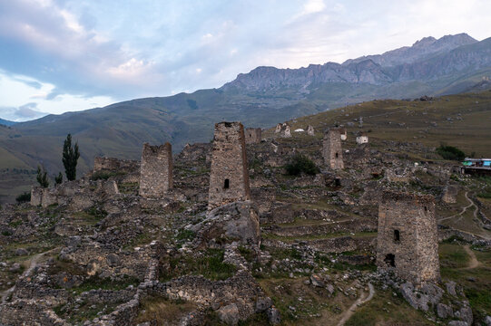 Aerial view of ancient stone towers piercing the sky amidst rugged terrain, as the mountains stand guard, framing the village, Chechen Republic, Russia.