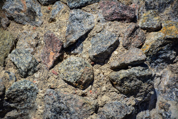 rugged, natural stone texture. Grey, brown, and reddish texture with uneven surface of stones. Texture overlay for graphic design and digital art. Mockups for stone or concrete surfaces