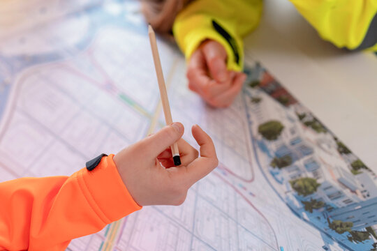 City planners discussing urban development strategies while analyzing detailed maps at a large table