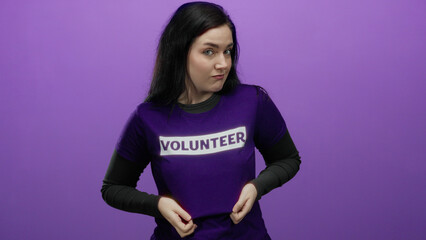 Obraz premium Woman in a purple volunteer t-shirt posing confidently against a vibrant purple background.