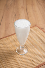 Cocktail in a tall glass on a light wooden table