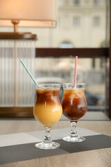 Bumblebee coffee in glass cocktail glasses on the table in a coffee shop. Black coffee with orange juice.