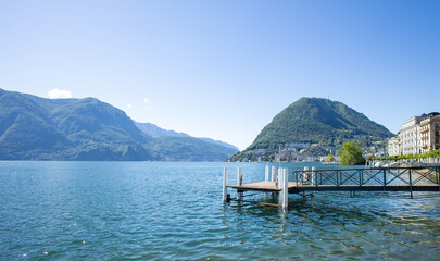 Detail of an old pier on Lake Ceresio in Lugano.
A sunny day and extraordinary landscape with a view of Mount San Salvatore. No people.