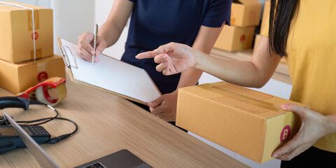 E-commerce. Two women managing inventory and packaging orders in a modern workspace.