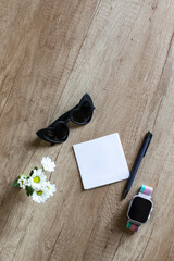 Minimalist desktop with accessories and small bouquet of white flowers