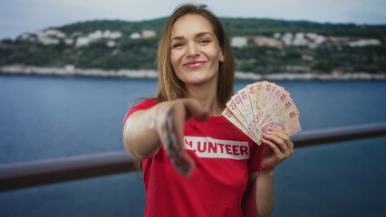 Woman holds fan of turkish lira banknotes with bare hand at seaside promenade; charity donation optimism.