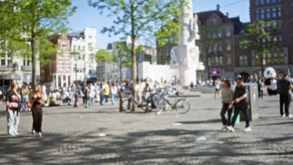 Bustling square in amsterdam with blurred people enjoying a sunny day surrounded by historic buildings under a clear blue sky highlighting urban vibrancy and leisure.