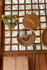 Obraz premium Woven baskets and citrus hanging in sunlit wooden shelter, showcasing traditional craftsmanship and rustic charm