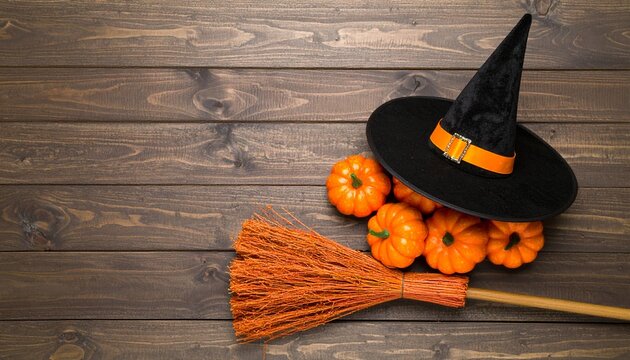 Halloween Witch's Hat, Broom and Pumpkins on a Rustic Wooden Background for Autumn Celebrations