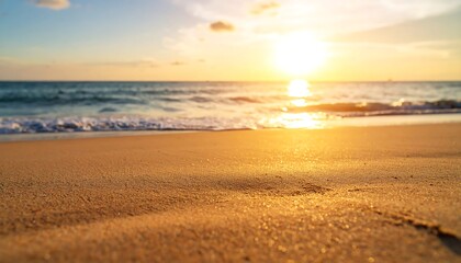 Obraz premium Serene beach escape with golden sands meeting the gentle waves under a radiant sunset
