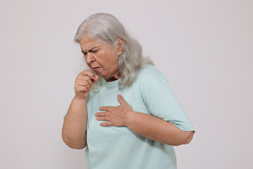 Portrait of senior indian elderly woman coughing - isolated on white background