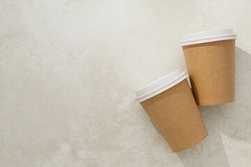 Two disposable coffee cups with lids on marble surface