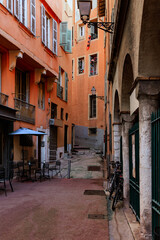 Narrow street in Nice, old colorful buildings in old town
