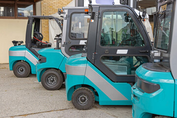 New Electric Powered Forklifts Trucks Parked in Front of Warehouse Building