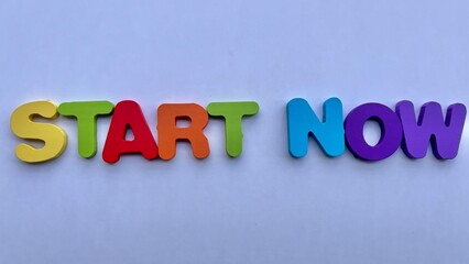 Colorful "START NOW" Wooden Letters on a White Background