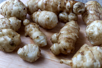 Fresh Jerusalem Artichokes on a Wooden Cutting Board in Natural Lighting