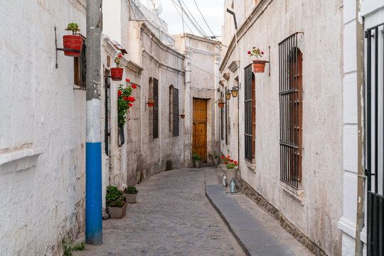 Enge Gasse mit wei&szlig;en Sillarstein-Mauern, Blument&ouml;pfen und historischer Architektur in Arequipa, Peru