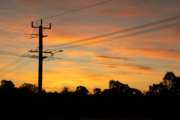 power lines criss-crossing the sky at sunset