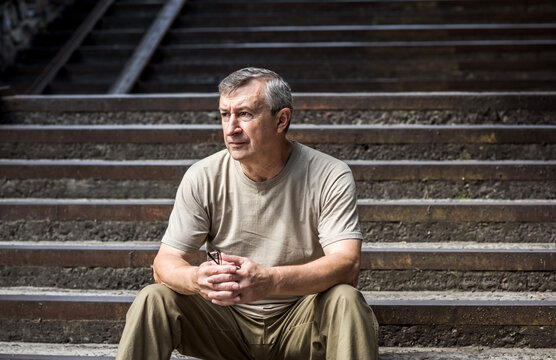 Pensive European senior man, emotional portrait of reflection and life challenges. Emotive portrait of a 55–65 year old man outdoors
