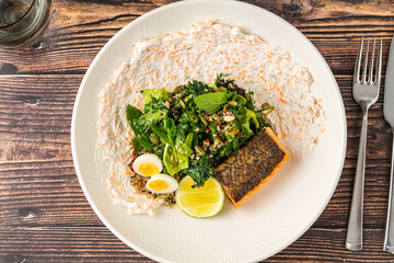 Fresh grilled salmon with greens, eggs, and creamy dressing