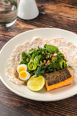Fresh grilled salmon with greens, eggs, and creamy dressing