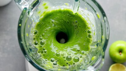 Healthy green smoothie with fresh fruit swirling in a glass blender, top down view. - Powered by Adobe