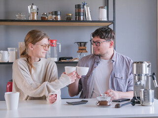 young couple tasting coffee at home , making coffee in the morning
