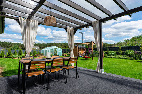 The terrace behind the house is made of beams, the roof is covered with polycarbonate.