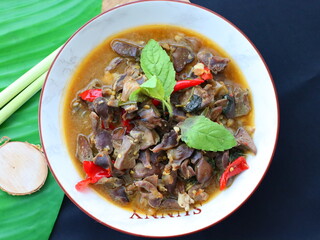 Spicy Thai stir-fry with chicken offal, cooked with garlic, chili, and fresh holy basil leaves, delivering a rich, aromatic, and flavorful dish perfect with steamed rice.