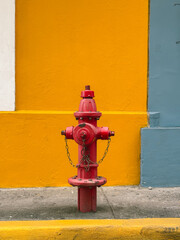 Red Fire Hydrant Against Colorful Wall