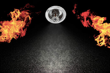 Image of Fire Sprinkler Spraying with fire background. Fire sprinklers are part of an overall safety protocol for fire and life safety.