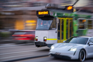 Tram and car rushing along a city street in Melbourne