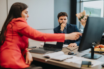 Two professionals collaborating at work, analyzing reports and engaging in meaningful discussions, embodying teamwork and productivity within a business environment.