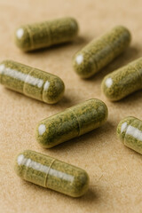 Herbal Capsules: Detailed studio shot of green herbal capsules with a focus on natural remedies and wellness. 