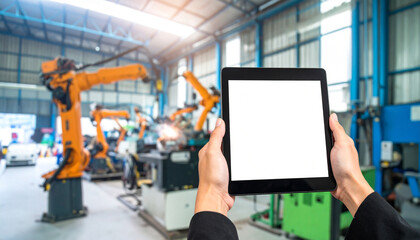 Hands holding tablet in factory Blurred robotic arms in workshop modern industry automation technology