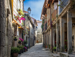 Combarro's cobblestone streets, lined with stone houses, wooden balconies, and flowers, reflecting the seafaring charm and traditional Galician architecture. Spain