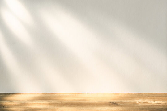 Warm sunlight streams through an open window, casting soft shadows on a wooden table in a serene indoor setting. - Powered by Adobe