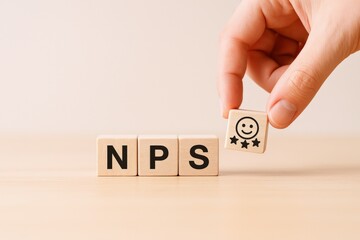 Net Promoter Score Concept: Hand Placing Smiley Face Block on NPS Wooden Blocks