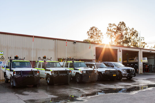 Mining fleet vehicles parked outside industrial mechanics workshop at sunrise