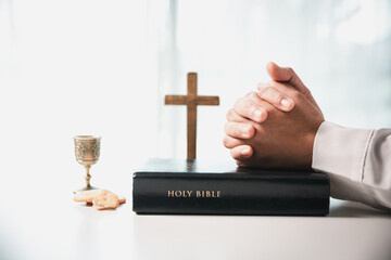 During the holy communion ceremony in church, a hand is extended in faith to receive the sacred...
