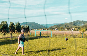 Mature woman plays volleyball outdoors.