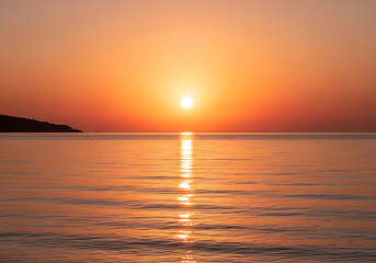 Golden sunset reflecting over the calm ocean waters, creating a peaceful and relaxing tropical beach vibe