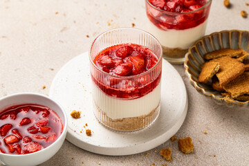 No bake individual cheesecake in glass with strawberry topping. Cheesecake cups. Summer cold parfait. Trifle with berry sauce. Home cooking. Selective focus.