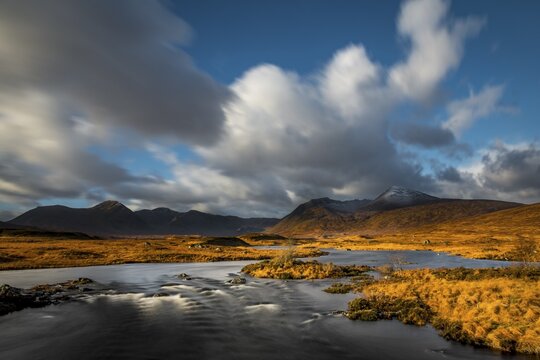 River Ba with mountain peaks of Meall a&acute;Bh&uuml;iridh and Clach Leathad in the background and dramatic clouds, Glen Coe, Rannoch Moor, west Highlands, Scotland, United Kingdom