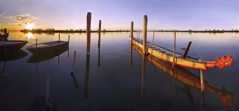 Sunset at the landing stage in Cavallino Harbour, dragon boat, Venice, Italy